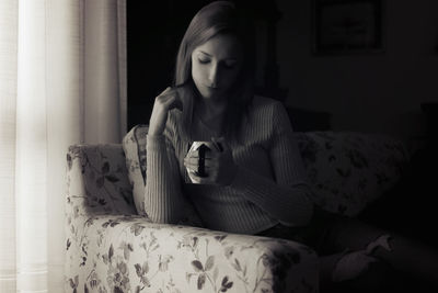 Woman sitting on bed at home