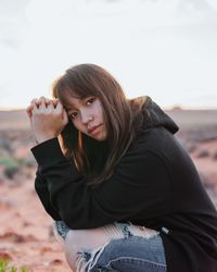 Portrait of beautiful young woman lying on land