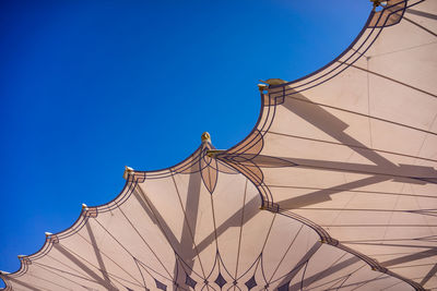 Directly below shot of parasols against clear blue sky