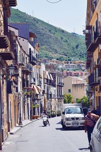 Street amidst buildings in city during sunny day