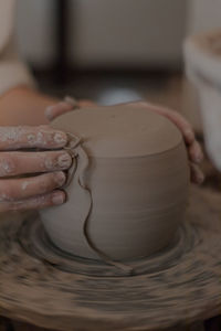 Midsection of person making pot