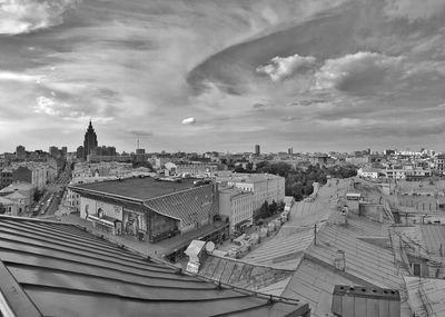 High angle view of buildings in city against cloudy sky