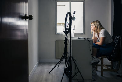 Female fashion model recording through mobile phone at studio