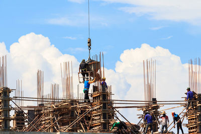 Cranes at construction site against sky