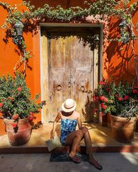 Full length of woman sitting at entrance