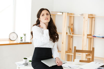 Frustrated businesswoman sitting on table at office