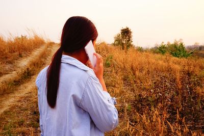 Woman standing on field against sky