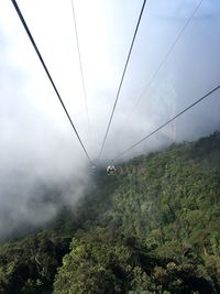 Overhead cable car over mountain against sky