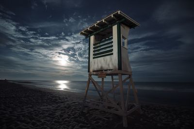 Lifeguard hut at beach against sky