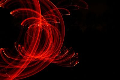 Close-up of red light painting against black background