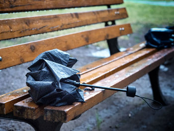 High angle view of wet umbrella on bench in park