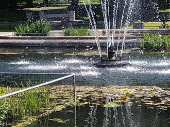 Water splashing in fountain against lake