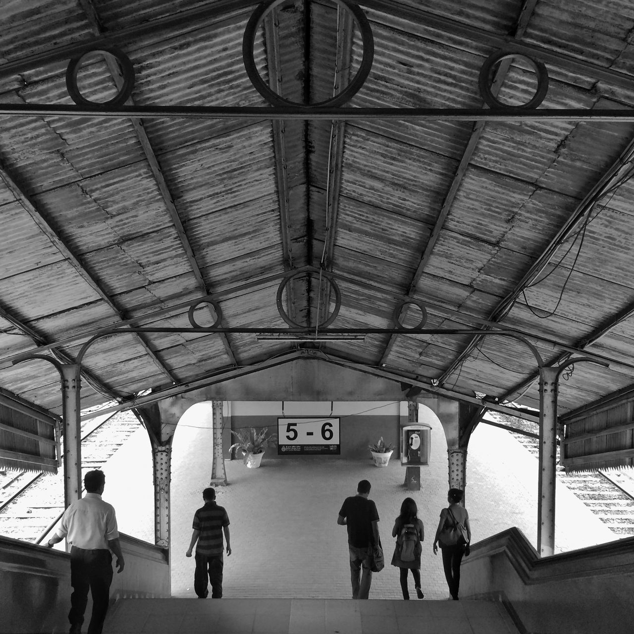 indoors, men, lifestyles, architecture, person, built structure, walking, ceiling, leisure activity, large group of people, full length, railroad station, standing, travel, medium group of people, rear view, city life, group of people