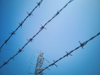 Low angle view of barbed wire against clear sky