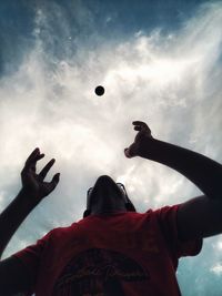 Low angle view of man playing with ball against sky