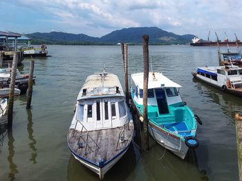 Boats moored in sea against sky