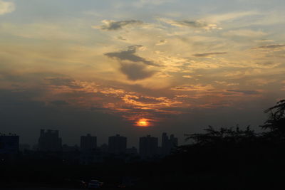 Silhouette buildings against sky during sunset