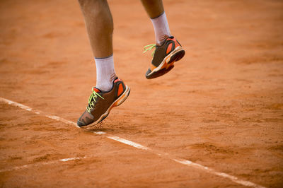 Low section of man playing on ground in court