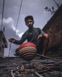 Young man playing with toy on land against sky