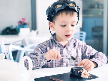 Portrait of cute boy holding table