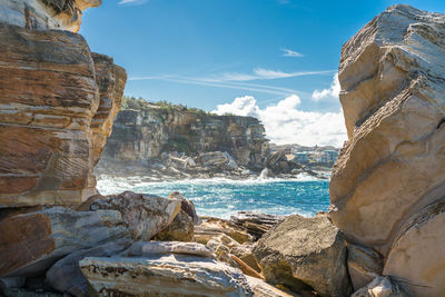 Rock formation on beach against sky