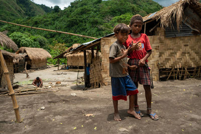 Rear view of people standing on farm