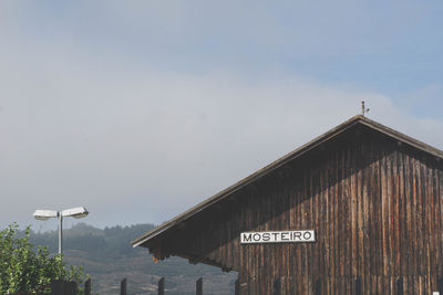 Information sign on roof of building against sky