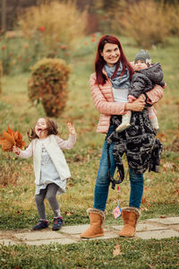 Full length of smiling girl standing against plants