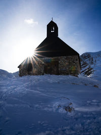 Church by building against sky during winter