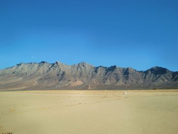 Scenic view of mountains against blue sky