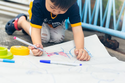 Full length of child holding paper on table