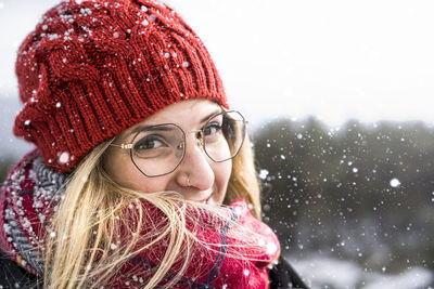 Close-up portrait of woman wearing knit hat outdoors during winter