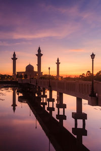 Reflection of building on water at sunset