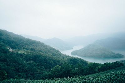 Scenic view of river and mountains against sky