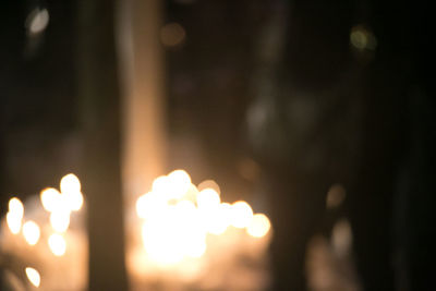Close-up of burning candles against blurred background