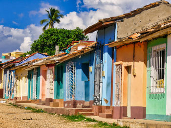 Multi colored houses by building against blue sky