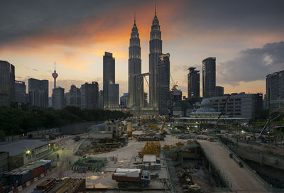 Petronas towers with cityscape against sky during sunset