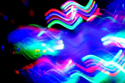 Close-up of multi colored light trails at night