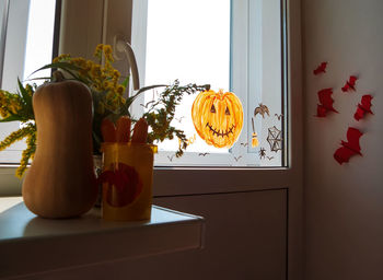 Child painting pumpkin window preparing celebrate halloween. kid draws decorates room interior