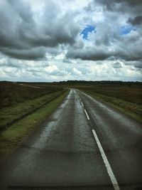 Empty road against cloudy sky