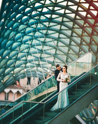 Full length portrait of young woman on railing