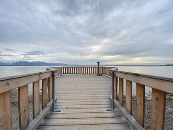 Wooden pier on sea against sky