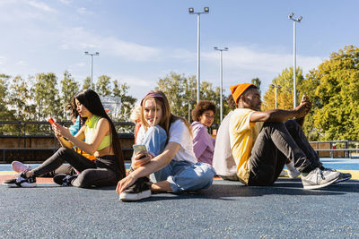 Low angle view of friends sitting on street