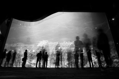 Group of silhouette people in water at night