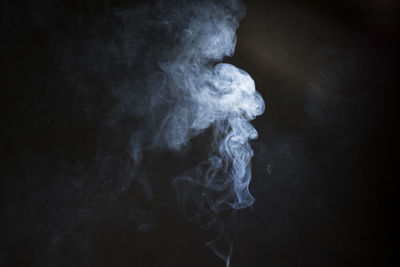 Close-up of smoke emitting from black background