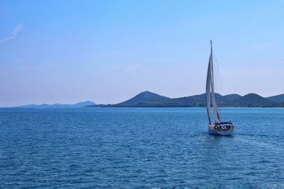 Sailboat sailing on sea against sky