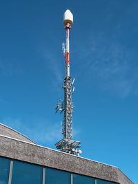 Low angle view of communications tower against blue sky