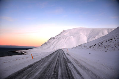 Scenic view of snowcapped mountains against sky during sunset