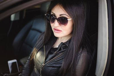 Portrait of woman wearing sunglasses in car