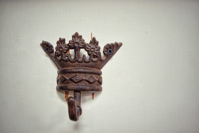 Close-up of rusty coat hook on white wall